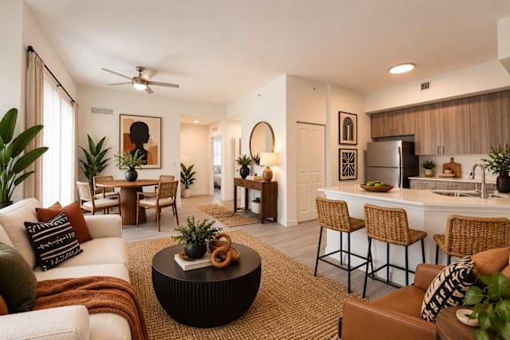 A modern living room with a kitchen in the background.