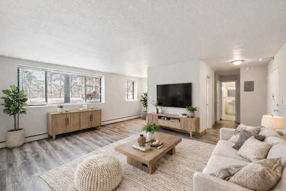 A modern living room with a large couch, a coffee table, and a television.