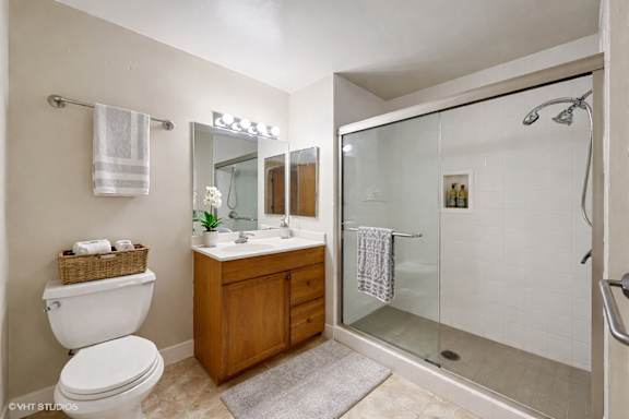 A bathroom with a toilet, sink, mirror, and shower.