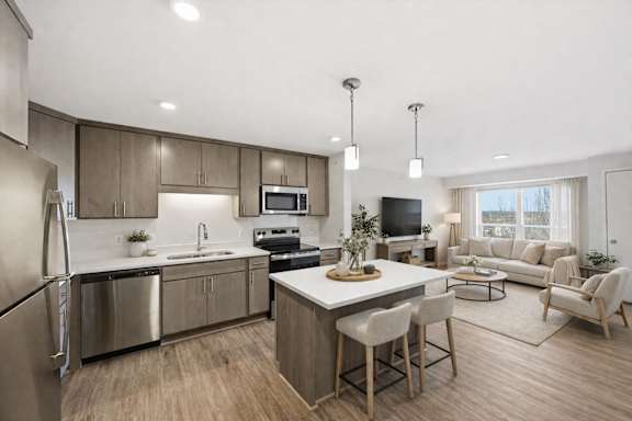A modern kitchen with a dining area and a living room.