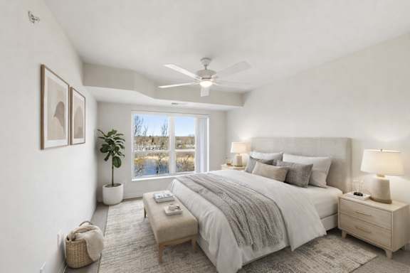 A well-lit bedroom with a large bed, a nightstand, and a window overlooking a snowy landscape.