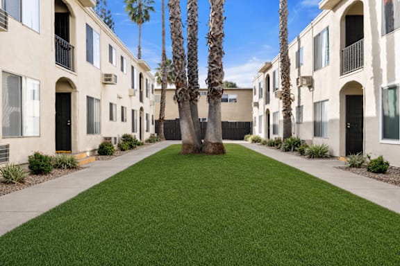 A row of houses with a green lawn in the middle.