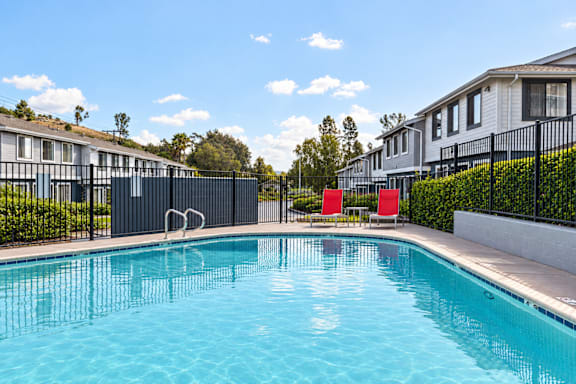 A swimming pool in front of a row of houses.