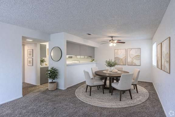 A dining room with a round table and chairs.