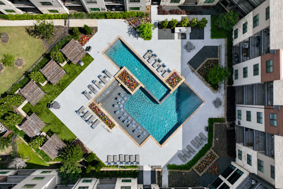 An aerial view of a pool surrounded by buildings.