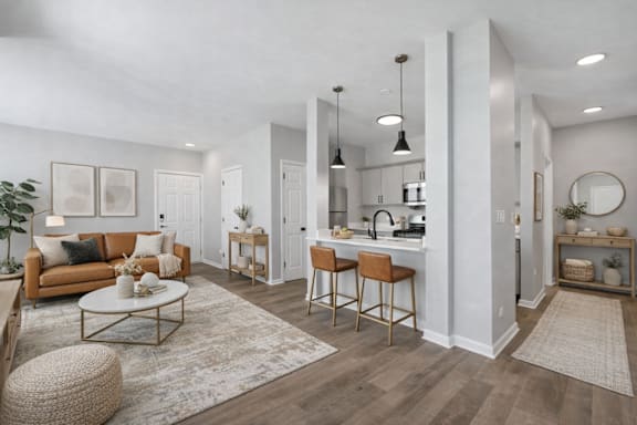 A well-lit, modern living room with a kitchen area in the background.