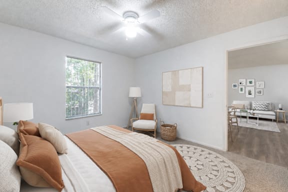 A bedroom with a large bed and a couch in the background.