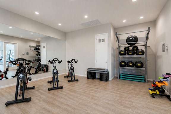 A room with exercise equipment and a bench.