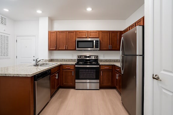 A kitchen with wooden cabinets and stainless steel appliances.
