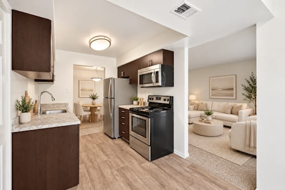 A modern kitchen with a stainless steel refrigerator and grey cabinets.