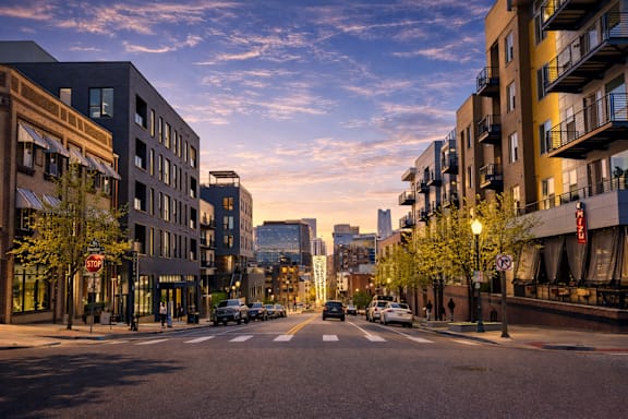 A city street with cars and buildings on either side.