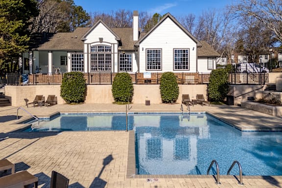 Crystal clear shimmering swimming pool with chairs around at Radbourne Lake Apartments, Charlotte, NC