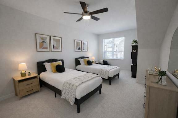 A bedroom with two beds and a ceiling fan.