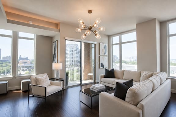 A living room with a white couch and a chandelier.