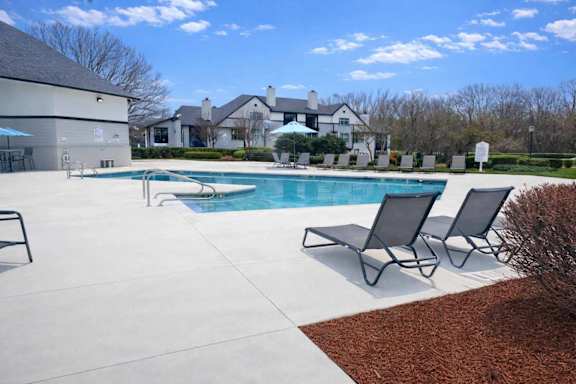 A large white house with a pool in front.