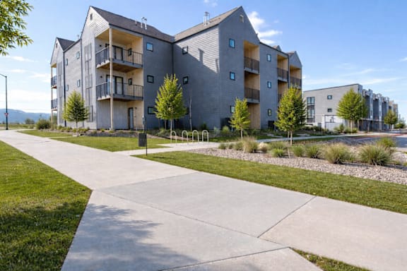 A modern apartment complex with a walkway in front.
