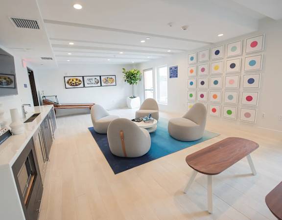 A modern kitchen with a white counter and a blue rug on the floor.
