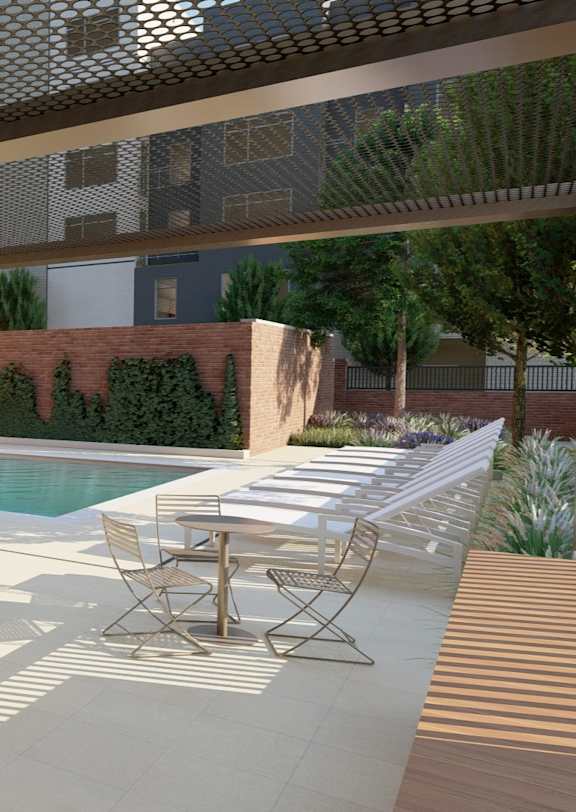 A pool area with chairs and a table under a shaded roof.