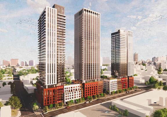 A cityscape with three tall buildings and a red building in the foreground.
