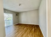 Thumbnail 4 of 5 - an empty living room with hardwood floors and a balcony at Lakeside @ Biscayne Gardens,North Miami, FL,33181