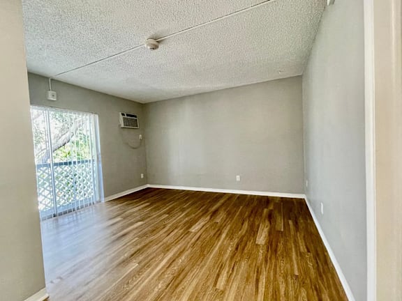 an empty living room with hardwood floors and a balcony at Lakeside @ Biscayne Gardens,North Miami, FL,33181
