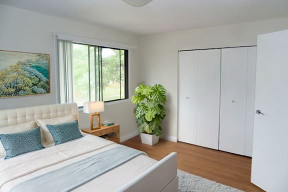 A bedroom with a large bed and a painting on the wall.