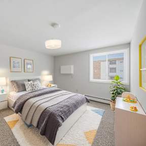 A bedroom with a bed, nightstands, and a window.