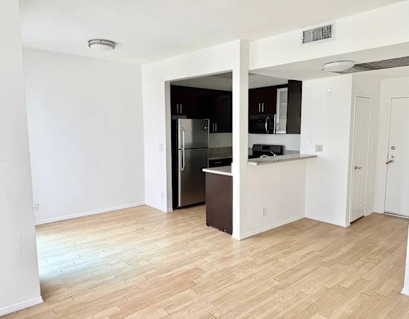 A kitchen with a refrigerator, microwave, and oven.