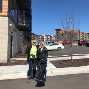 two women standing on a sidewalk in front of a building