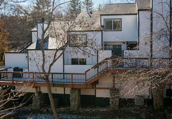 the back of the house with a deck and a tree