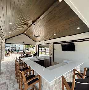 a patio with tables and chairs and a pool