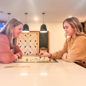 two women playing a board game at a table