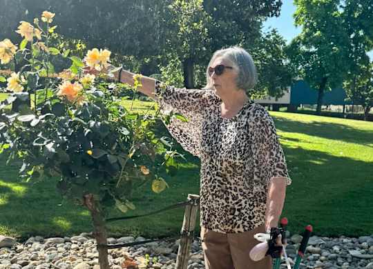 A woman is standing in a garden at River Commons Senior Living, Redding, California