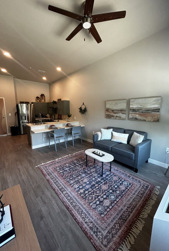 a kitchen and living room with white cabinets and wood floors