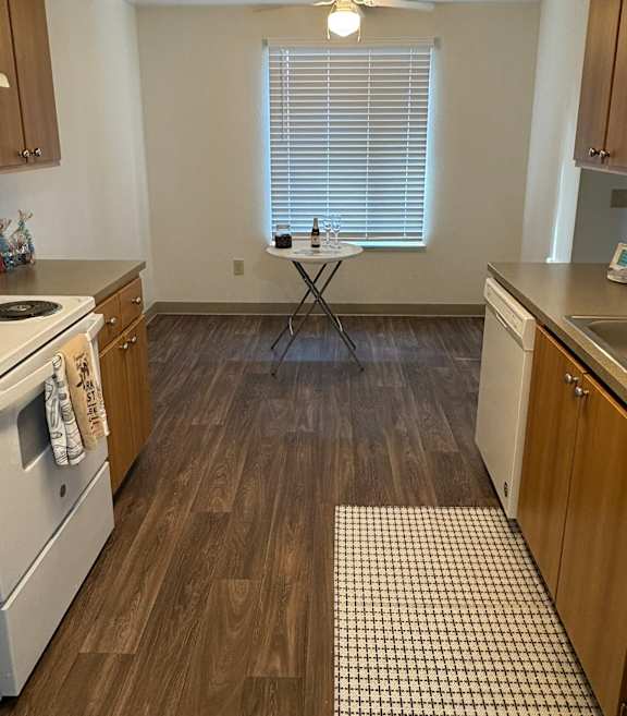 A room with wooden flooring and a window with blinds.