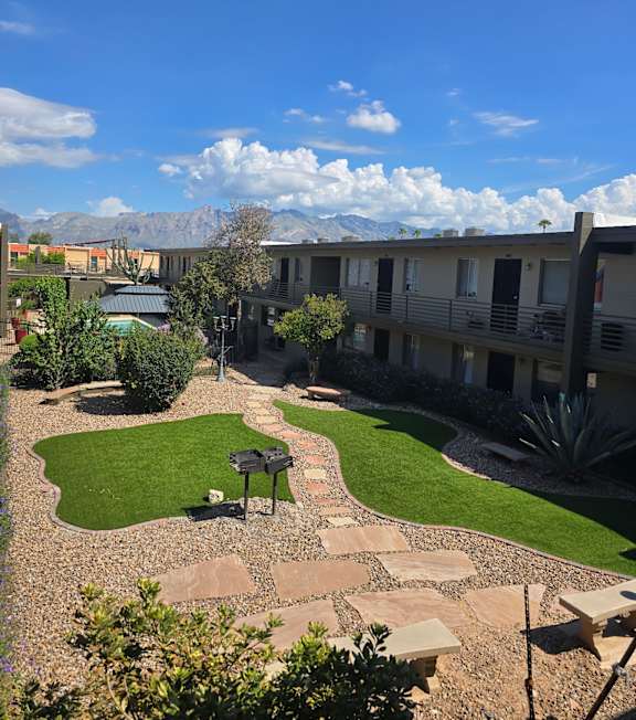 A courtyard with a grassy area and a bench.