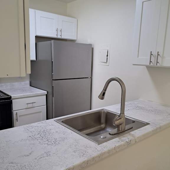 A kitchen with a sink and a refrigerator.