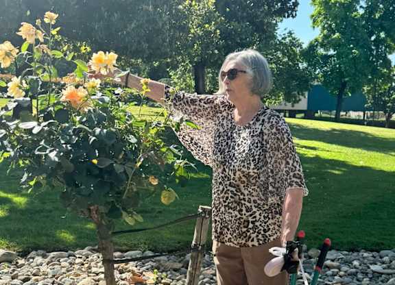 A woman is standing in a garden at River Commons Senior Living, Redding, California