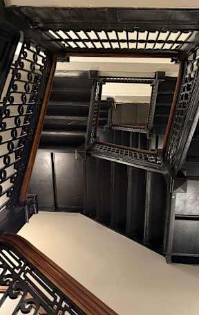 A staircase with a mirror on the side.