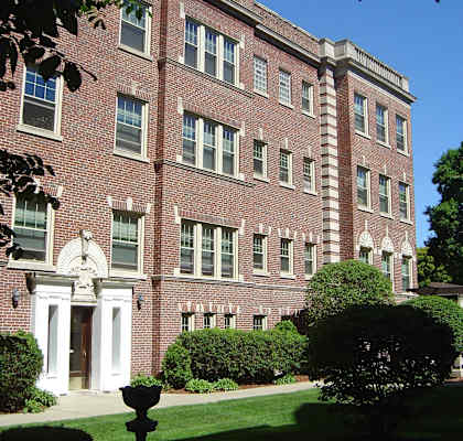 A red brick building with white trim and a white door.