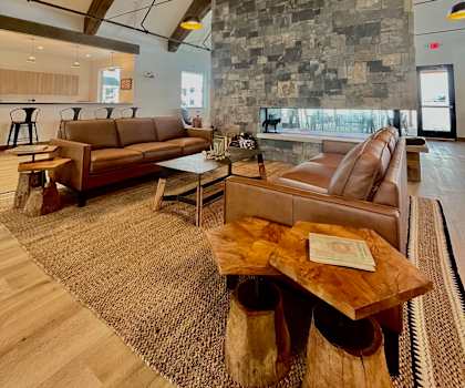 A modern living room with a stone wall and wooden furniture at Silverbrook Apartments Apartments, Ridgeland, 59901