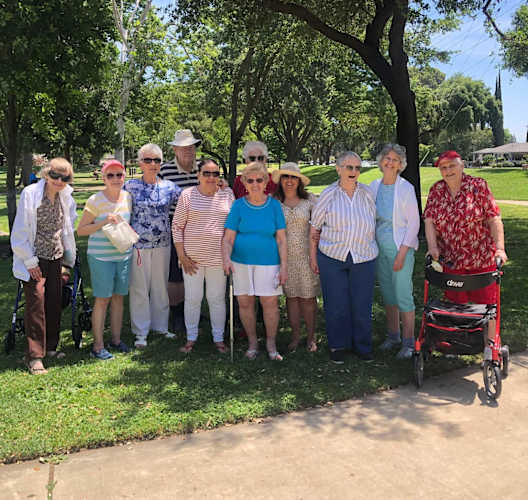 a group of seniors standing under a tree in a park at Lodi Commons Senior Living, Lodi, 95240