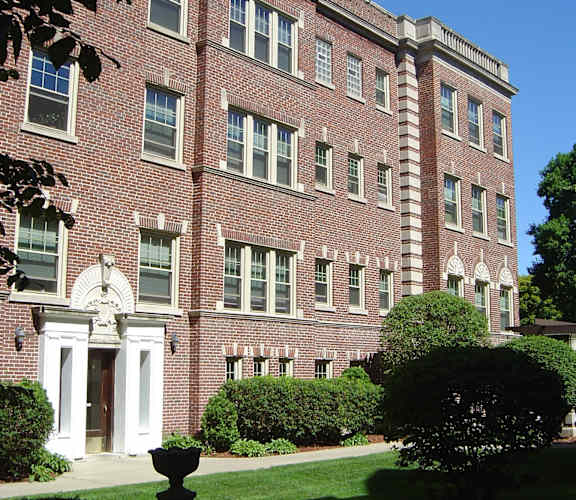 A red brick building with white trim and a white door.