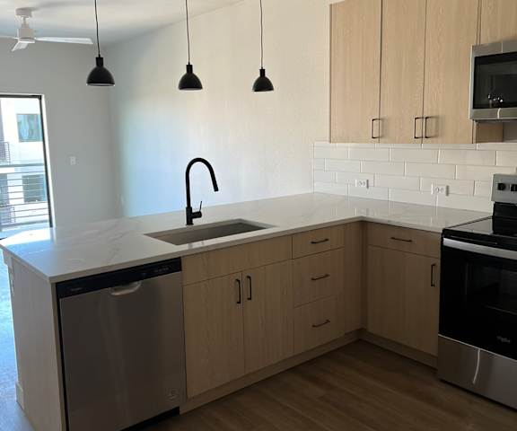 an empty kitchen with wooden cabinets and a sink