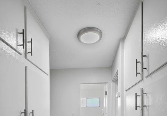 A hallway with white doors and a logo for Beach Front Property Management.