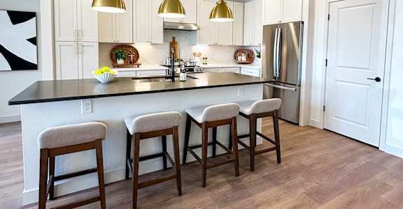 A kitchen with white cabinets and a black countertop.