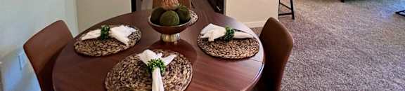 a dining room table in a living room with a kitchen  at Mullan Reserve Apartments, Missoula, MT, 59808