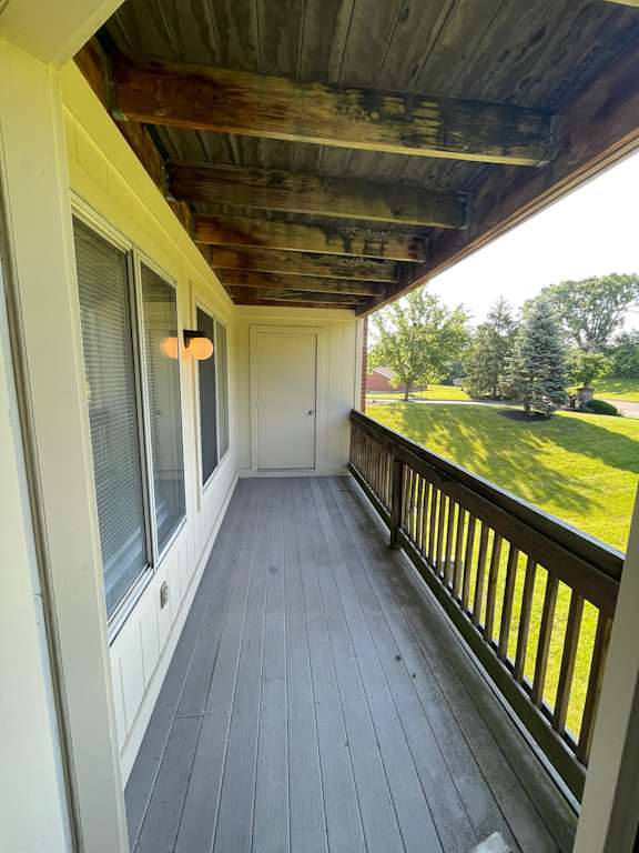 A wooden deck with a door and windows.