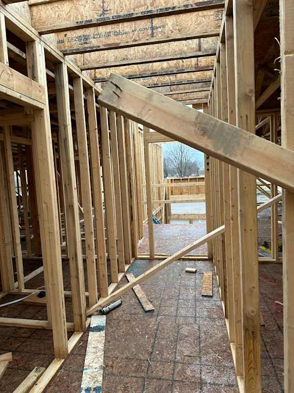 A view of a house under construction with wooden beams and flooring.