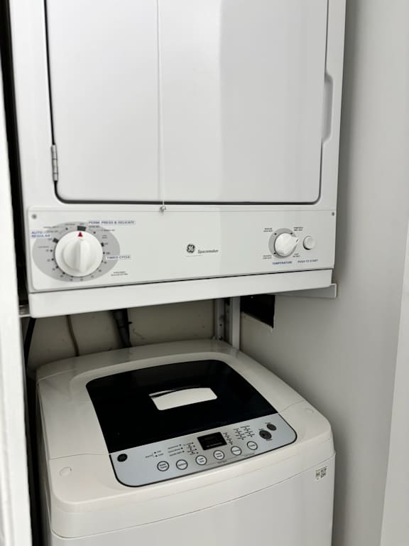 A white washing machine with a black control panel is installed in a wall.